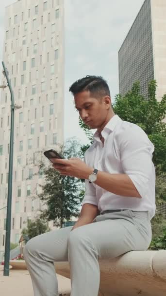 Vertical Video Νεαρός Επιχειρηματίας Που Χρησιμοποιεί Κινητό Τηλέφωνο Ενώ Κάθεται — Αρχείο Βίντεο