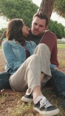 VERTICAL VIDEO: Couple in love spending time together in the park on picnic