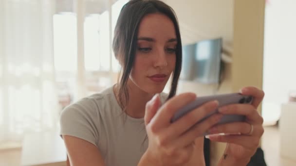 Jeune Femme Utilisant Téléphone Portable Tout Étant Assis Dans Appartement — Video