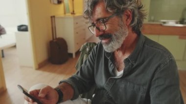 İçerideki akıllı telefonu kullanarak gülümseyen son sınıf öğrencisinin yakın plan fotoğrafı.