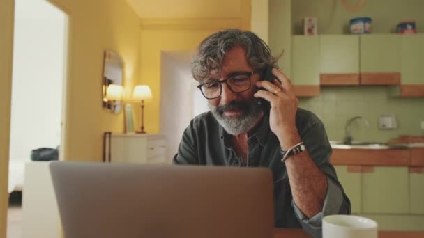 Olgun Adamı Laptopta Çalışıyor Cep Telefonuyla Konuşuyor — Stok video