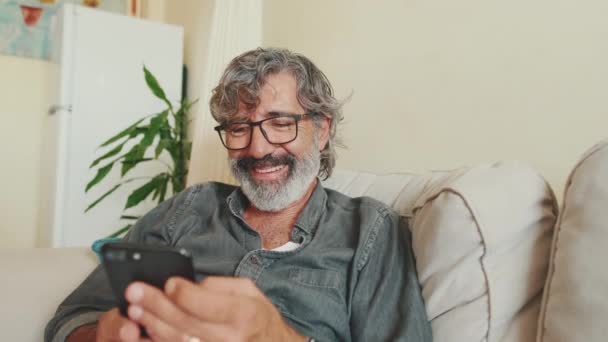 Close Middle Aged Man Relaxing His Couch While Using His — Vídeos de Stock