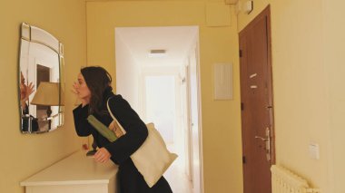 Paltolu genç bayan aynaya bakıyor.