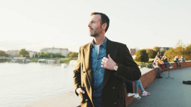 Nehrin kenarında yürüyen bir adam.