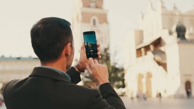 Adam eski şehrin meydanında fotoğraf çekiyor. Arka plan