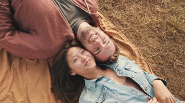 Parkta battaniyeye uzanmış genç bir çift. Yukarıdan görüntüle