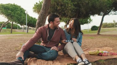 Parkta piknikte iyi vakit geçiren bir çift. Yakın plan.