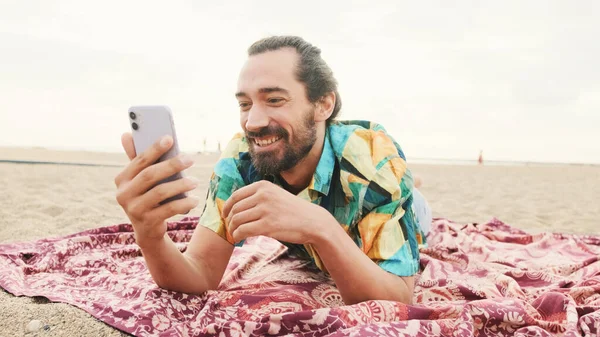 Joven Hombre Feliz Miente Hablando Por Videollamada Playa —  Fotos de Stock