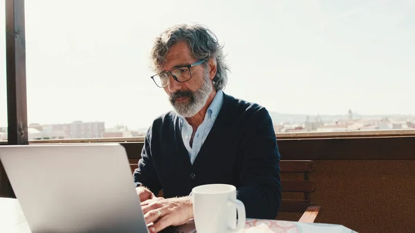 Homem Meia Idade Trabalhando Laptop Enquanto Com Café Sentado Varanda — Fotografia de Stock
