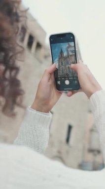 Dikey video, yakın çekim, genç kadın fotoğraf çekiyor.
