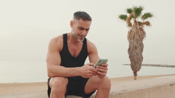 Зрілий Чоловік Спортивному Одязі Використовує Мобільний Телефон — стокове відео