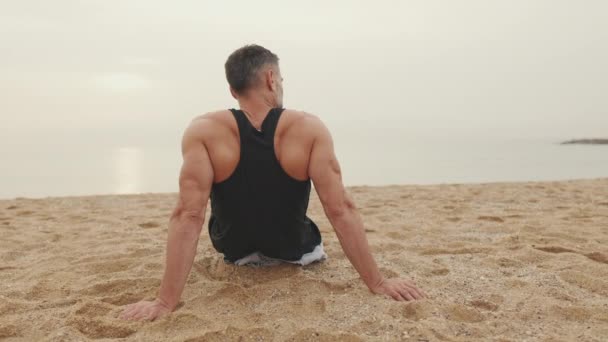 Mature Man Sits Sand Coast — Stock Video