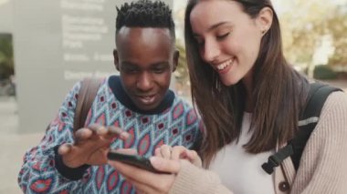 Close-up of a guy and a girl talking to each other and using a mobile phone