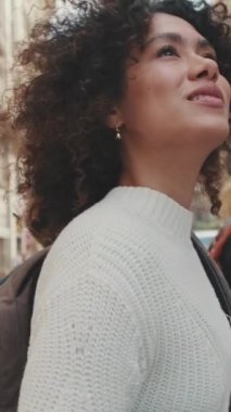 Dikey video, genç bayan turist yaya geçidi boyunca yürüyor.