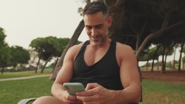 Sorridente Uomo Mezza Età Abbigliamento Sportivo Sta Utilizzando Telefono Cellulare — Video Stock