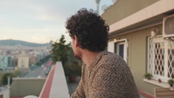 Młody Człowiek Stoi Balkonie Patrząc Dół Drogę Poniżej — Wideo stockowe