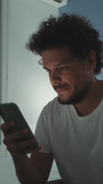 Mladý Muž Sedí Ložnici Drží Smartphone — Stock video