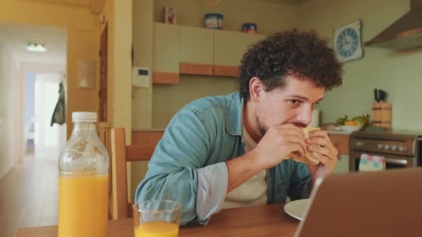 Mutfaktaki Masada Dizüstü Bilgisayarı Olan Genç Bir Adam — Stok video