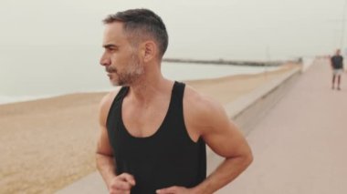 Spor kıyafetleri içinde olgun bir adam.