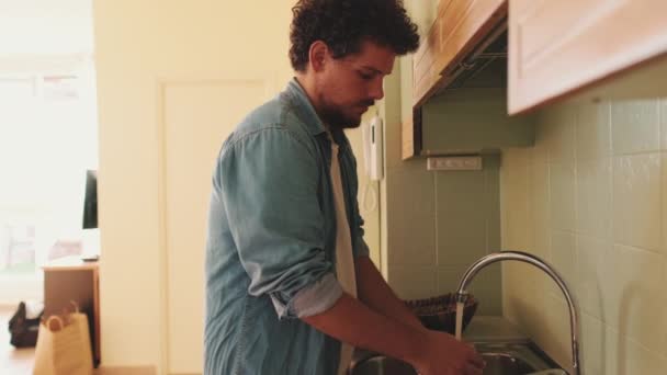 Jeune Homme Lave Les Légumes Dans Cuisine — Video