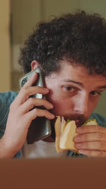 Νεαρός Τρώει Ενώ Κάθεται Στην Κουζίνα Και Φτιάχνει Λάπτοπ — Αρχείο Βίντεο