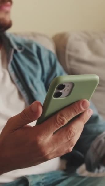 Hombre Molesto Sentado Sofá Usando Teléfono Móvil — Vídeos de Stock