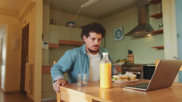 Unge Man Häller Apelsinjuice Glas Och Äter Lunch Köket — Stockvideo