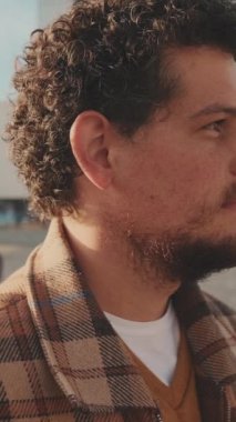 Başını çevirip kameraya bakan ve gülümseyen genç bir adamın yakın çekimi.