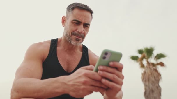 Homme Mûr Vêtements Sport Utilise Téléphone Mobile — Video