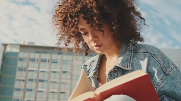 本を読んでいる若い女性のクローズアップ 大学の建物の外に座って勉強する学生 — ストック写真