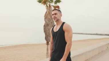 Spor giyimli olgun bir adam gezinti güvertesinde yürüyor.