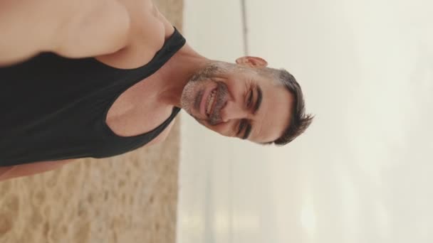 成熟した男メイキングビデオコールしながら立っている間に海辺の背景 — ストック動画
