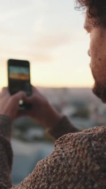 閉じる 若い男がバルコニーに立って 写真を撮る 携帯電話上のビデオ — ストック動画