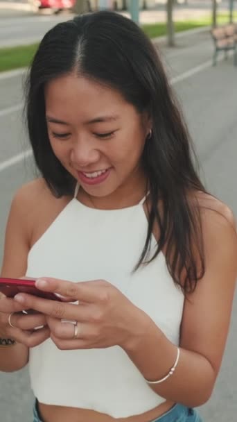 Усміхнена Молода Жінка Йде Вулиці Мобільним Телефоном Руках — стокове відео