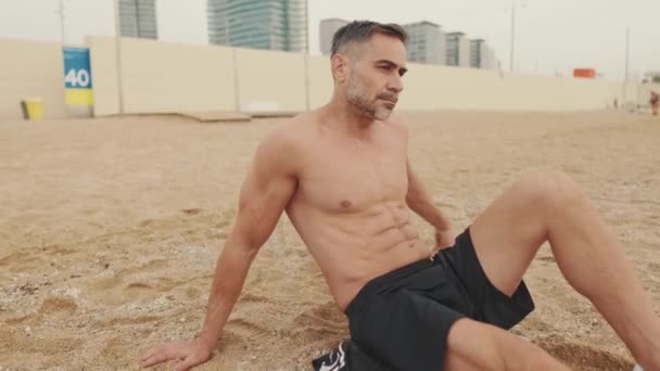 Ώριμος Άνδρας Οδηγεί Υγιεινό Τρόπο Ζωής Κάθεται Στην Άμμο Στην — Αρχείο Βίντεο