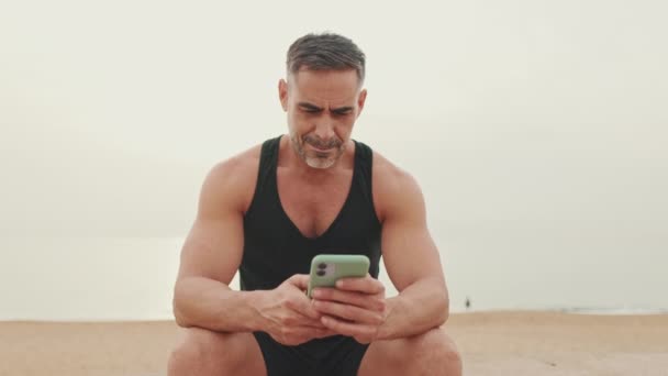 Starší Muž Sportovním Oblečení Používá Mobilní Telefon — Stock video