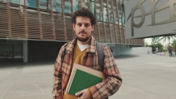 Chlápek Student Poznámkovými Bloky Rukou Stojí Před Univerzitní Budovy Dívá — Stock video