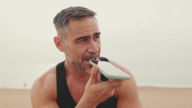 Kapat şunu, spor giyim bölümündeki olgun adam cep telefonundan sesli mesaj gönderiyor.