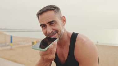 Kapat şunu, spor giyim bölümündeki olgun adam cep telefonundan sesli mesaj gönderiyor.