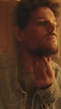 Genç adamın aynada kendine baktığı yakın plan.