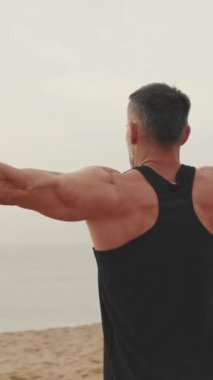 Orta yaşlı bir adam dışarıda egzersiz yapıyor.