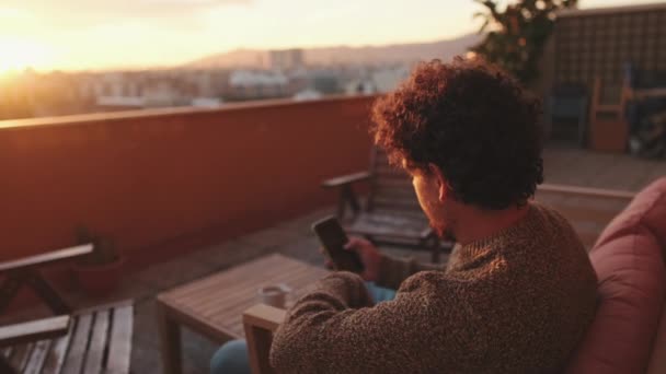 Jovem Senta Terraço Usa Telefone Celular — Vídeo de Stock