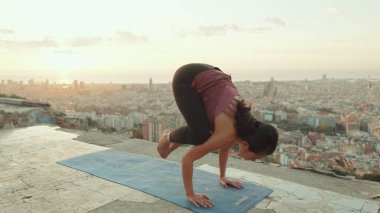 Kız şafak vakti gözetleme noktasında amuda kalkıp yoga yapıyor.