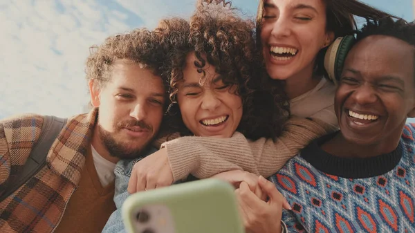 Szczęśliwi Uśmiechnięci Przyjaciele Wykonują Wideo Rozmowę Telefonu Komórkowego Czterech Uczniów — Zdjęcie stockowe