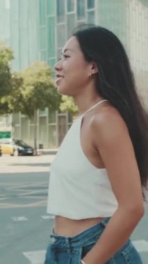 Yaya geçidinde yürüyen gülümseyen genç kadın