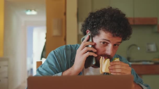 Genç Adam Mutfakta Oturup Dizüstü Bilgisayarla Çalışırken Yemek Yiyor — Stok video