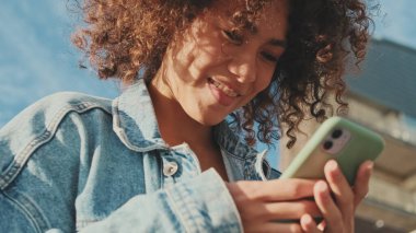 Cep telefonu kullanan genç bir kadının ellerini yakın plan çek.