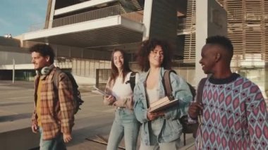 Classmates students walk down the street talking and laughing together
