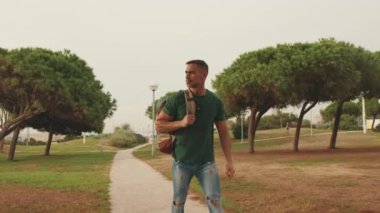 Şehir parkında yürüyen orta yaşlı bir adam.