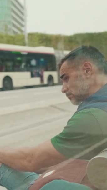 トラム停留所に座っている中年の男 — ストック動画